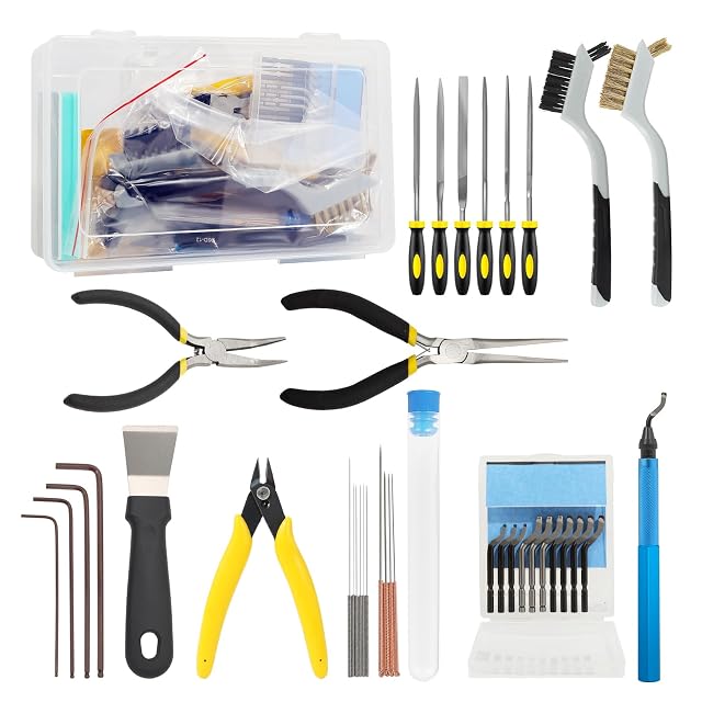 Kit étalé : boîte transparente, six limes, deux brosses, deux pinces à bec long, pince coupante, grattoir, quatre clés hexagonales, aiguilles dans un tube, dix lames et un ébavureur bleu