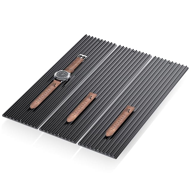 Trois modules noirs à lamelles d’aluminium côte à côte, avec une montre et des bracelets en cuir posés dessus
